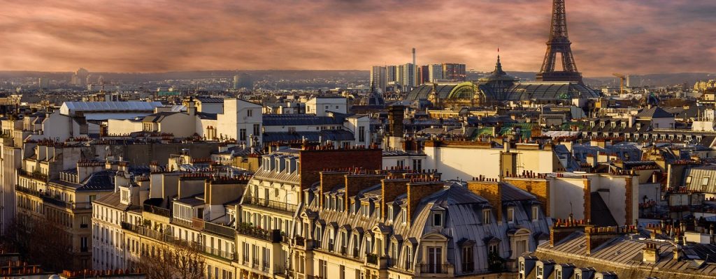 The city of Paris seen from above. City buildings in front and Eiffel tower behind.