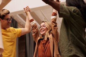 Happy theatre people holding hands and celebrating theatre's digital marketing