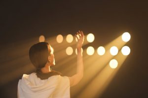 Woman looking up to the lights what is coming from holes