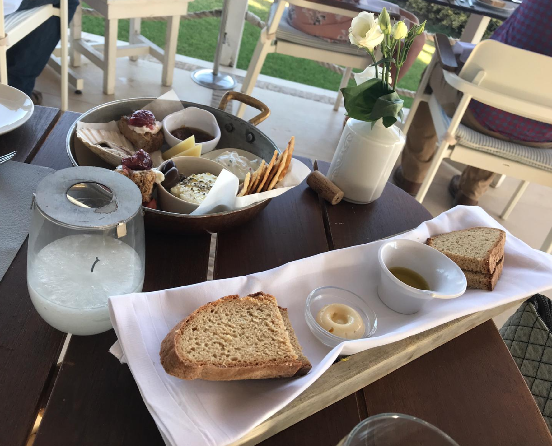 Pictured a tray with small traditional greek appetizer foods like feta cheese, olives and tzatziki.