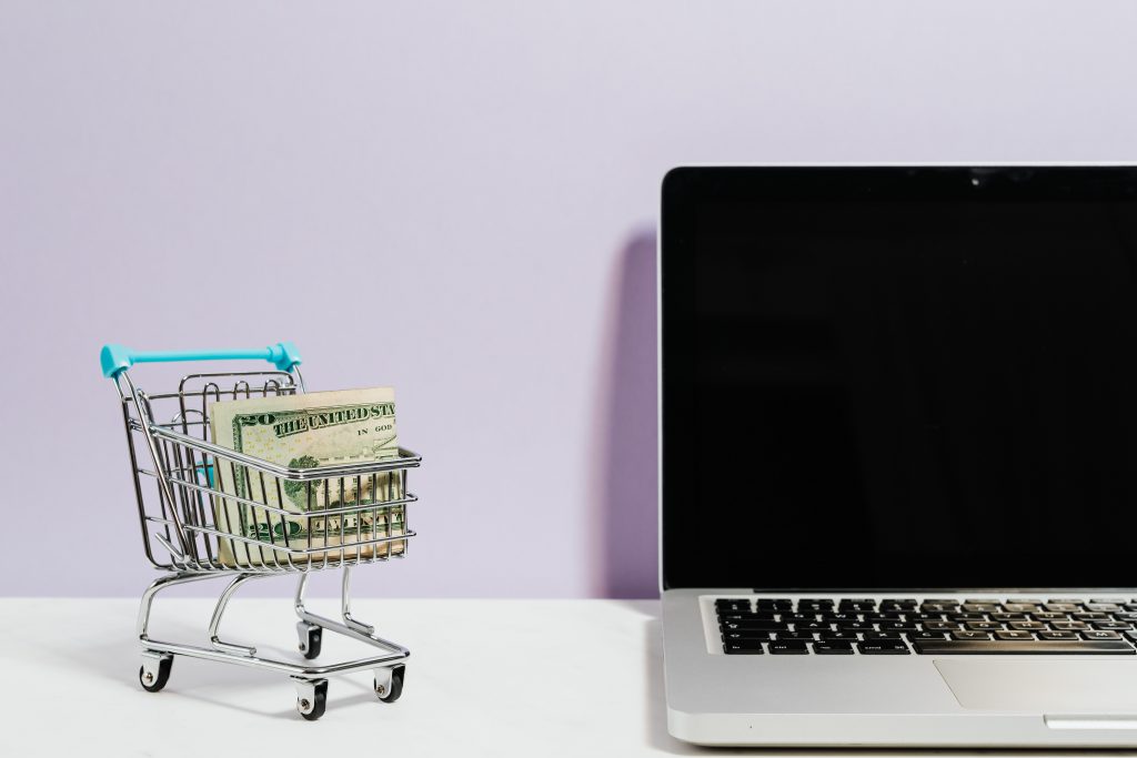 In the picture there is a computer and a shopping cart.The picture illustrates the online customer.