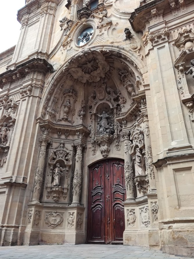 Basilica de  Santa Maria del Coro edestä otettu kuva, jossa näkyy suuret ovet ja patsaita