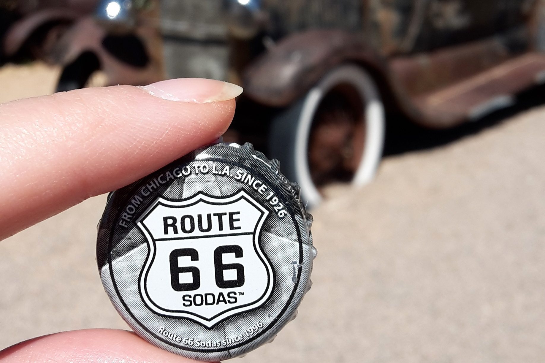 A hand holding a Route 66 bottle cork