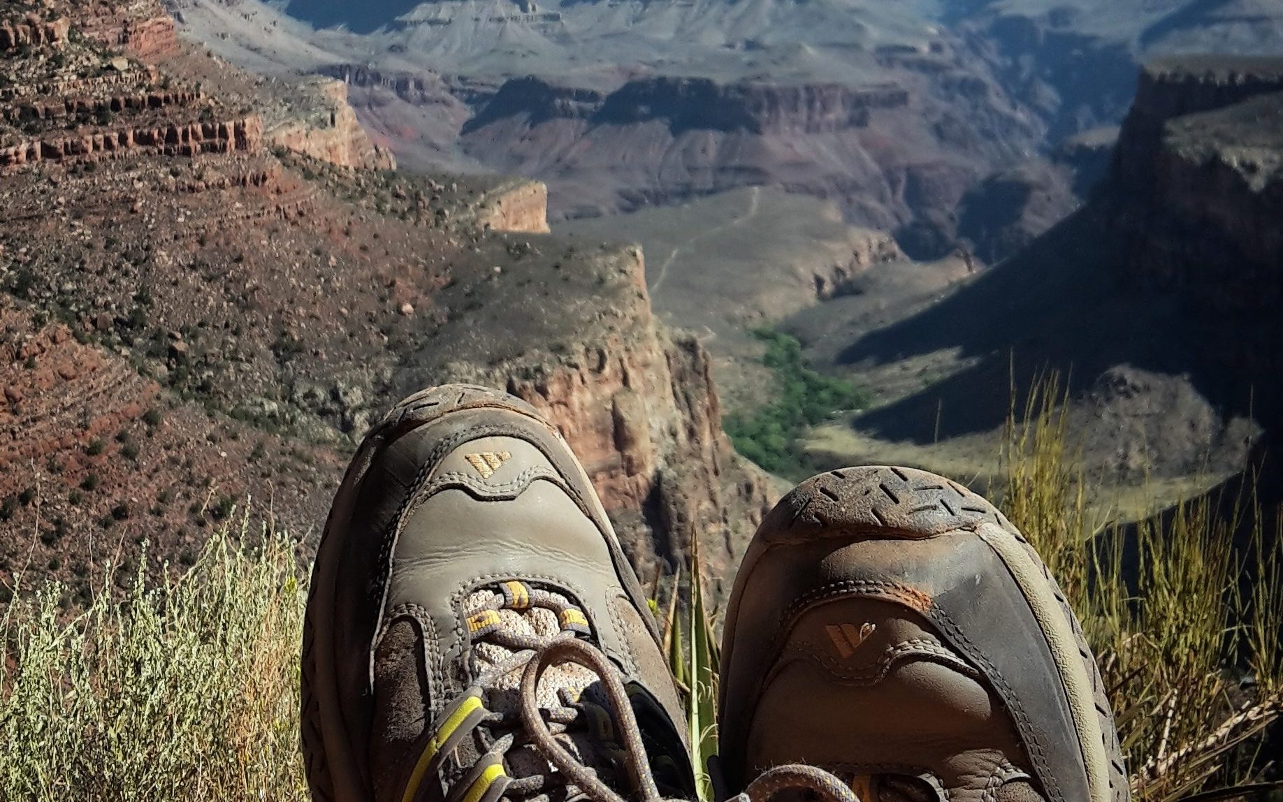 Hikers shoes in the front of the picture and grand canyon 