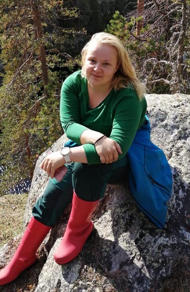 Teija Kontio istuu kesäisellä kalliolla kanjoninreunalla Kuusamossa.