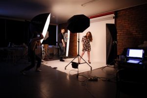 Three persons working on photoshoot in the photostudio.