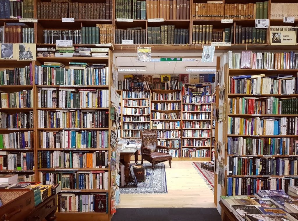 Practicticing literary tourism in Ireland bookstore with shelves full of books.