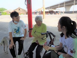 two people chatting with an old lady in a temple