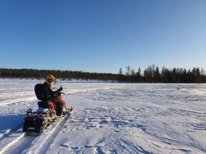 a guy in yellow helmet on a snowmobile, journey in the middle of nowhere