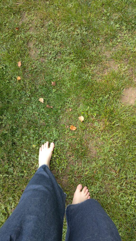 Walking on grass, which is one of the barefoot trail surfaces