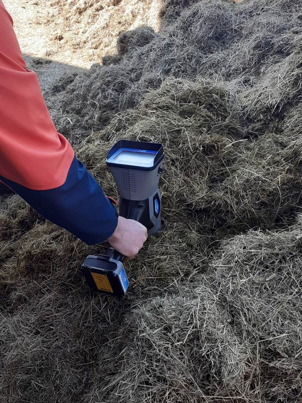 Henkilön käsi kannattalee mittauslaitetta tuotteen päällä.