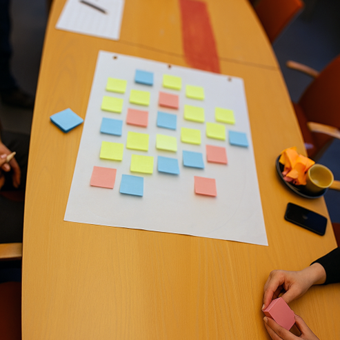 Pieniä muistiinpanolappuja pöydällä lepäävällä isolla arkilla.