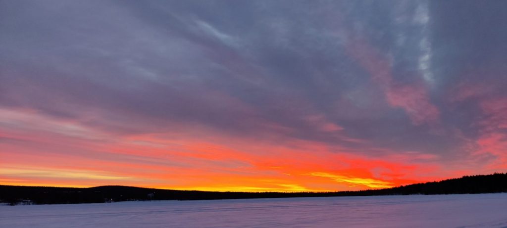 A colourful sunset on the ice of river Kemijoki in Rovaniemi.
